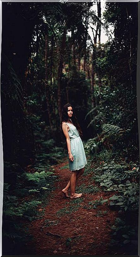 Woman walking barefoot through the forest